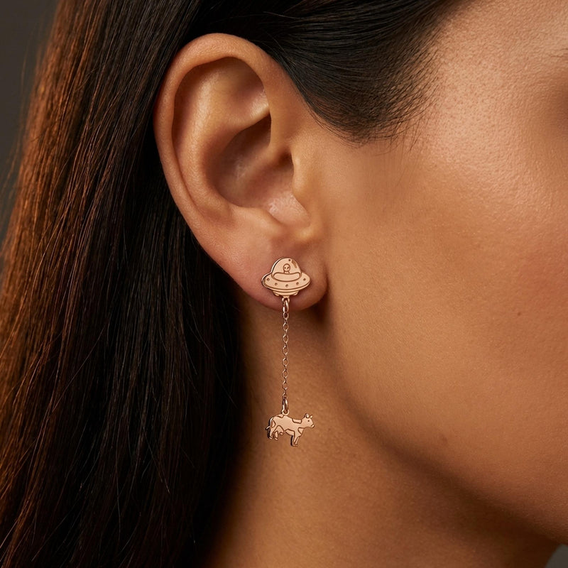 Pair of gold drop earrings showing a flying saucer beaming up a tiny cow (12 of 12)