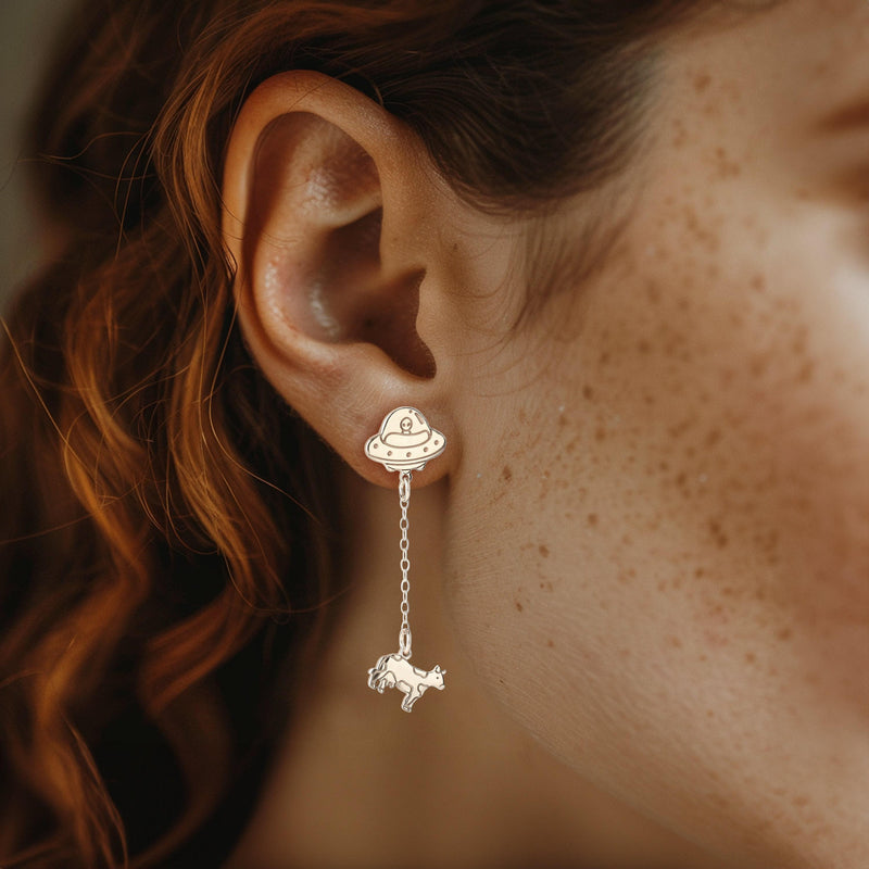 Pair of gold drop earrings showing a flying saucer beaming up a tiny cow (5 of 12)