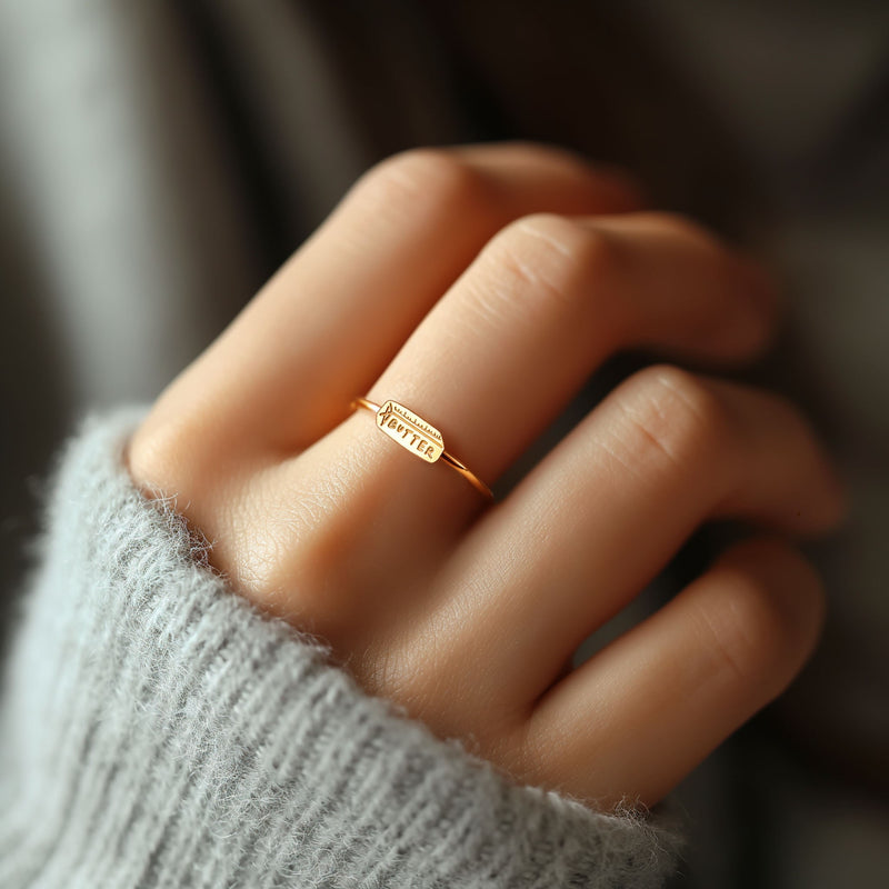 Gold ring with a small butter stick charm sitting flat on a thin round band (6 of 10)