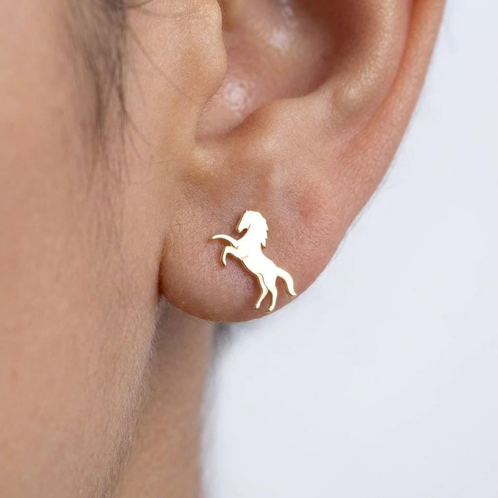 Small gold horse stud earrings, running horse silhouette, shown as a pair
