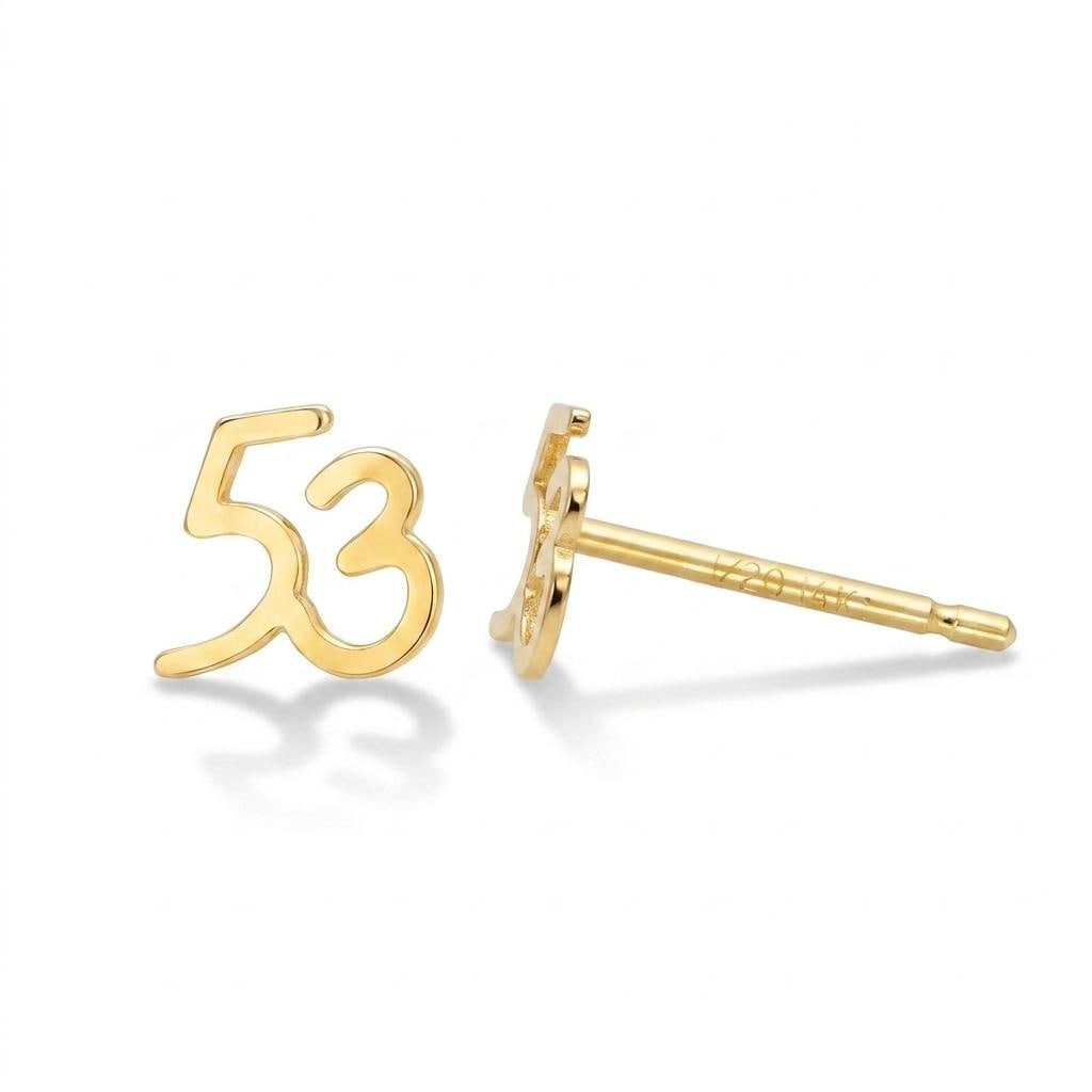 Pair of tiny gold football stud earrings with laced seams, shown on white