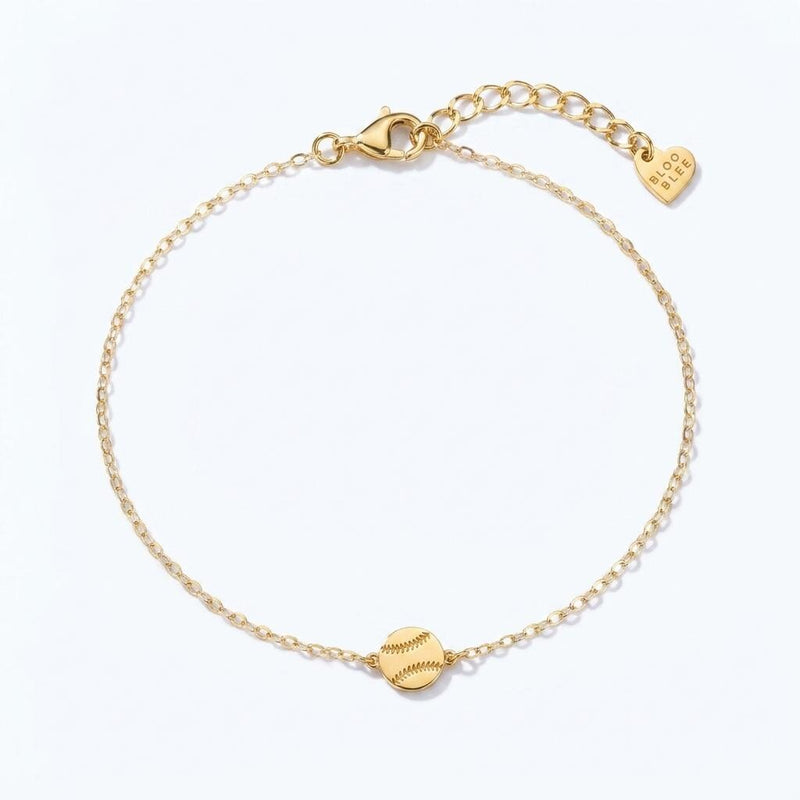 Thin gold chain bracelet with a very small softball charm with stitching