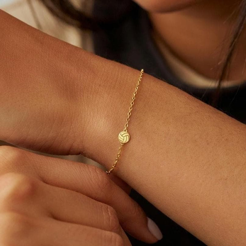 Thin gold chain bracelet with a small volleyball charm with curved panels (11 of 11)