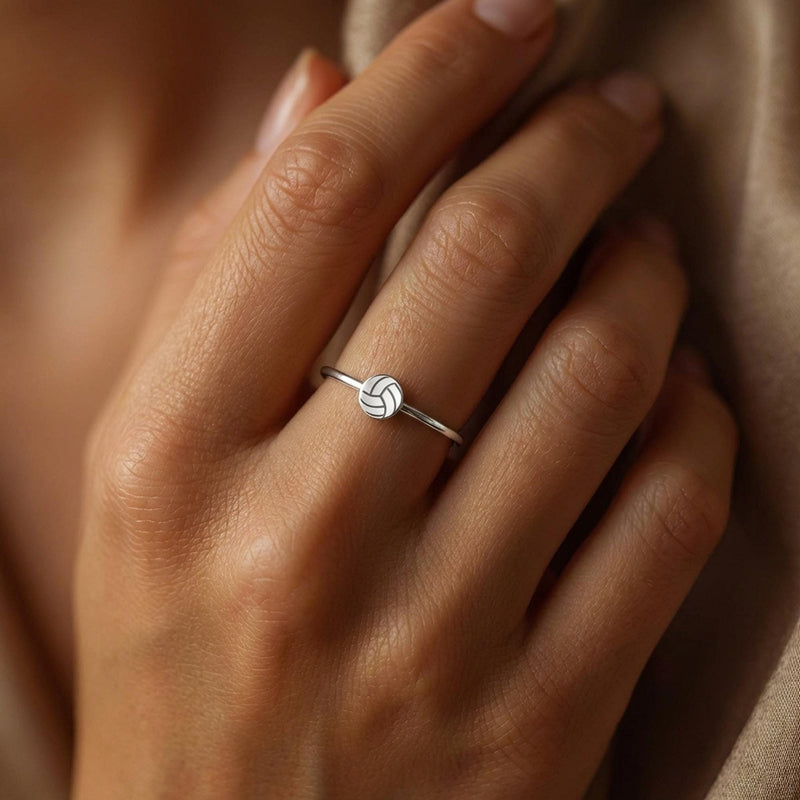Thin gold stacking ring with a tiny volleyball charm sitting flat on the band (3 of 7)