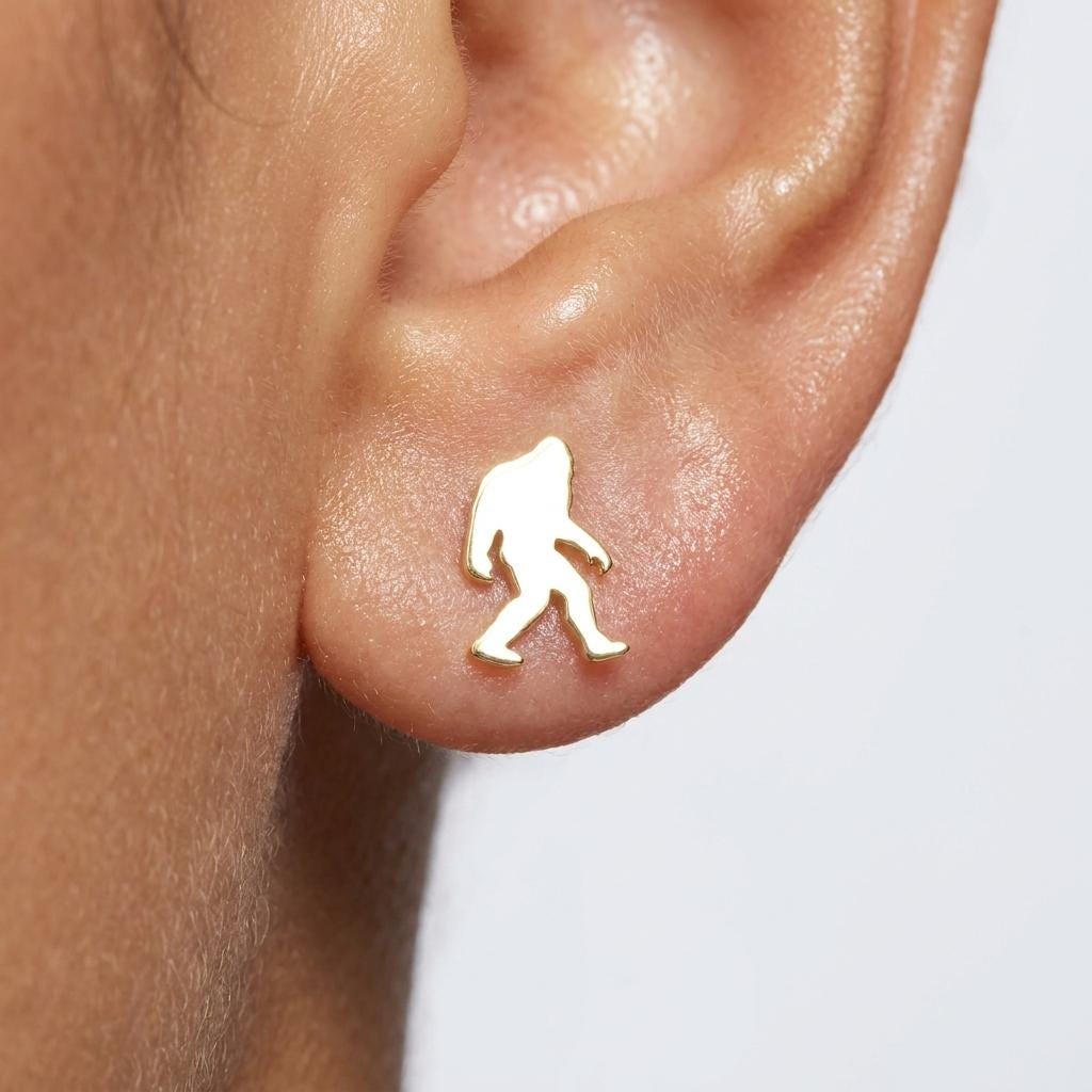 Pair of small gold Bigfoot stud earrings shown mid-stride with posts and backs (2 of 9)