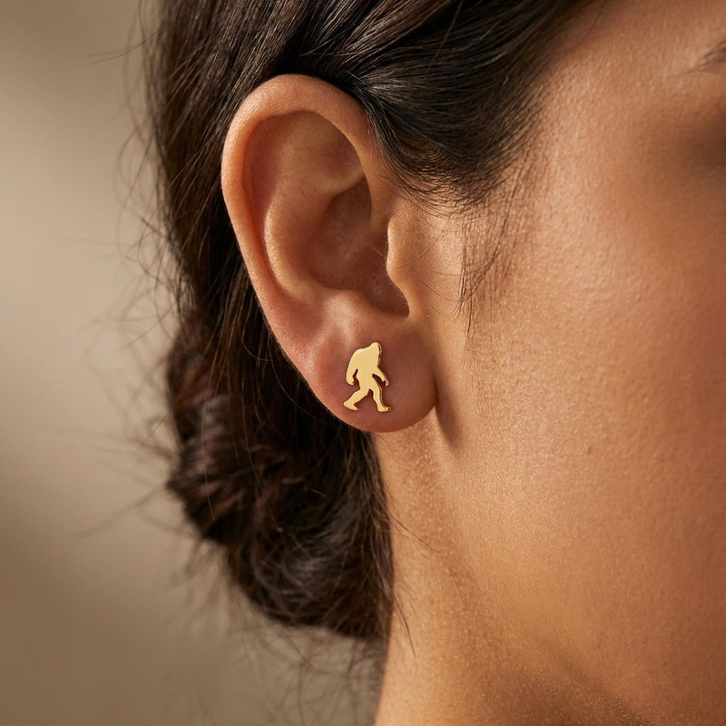Pair of small gold Bigfoot stud earrings shown mid-stride with posts and backs (9 of 9)