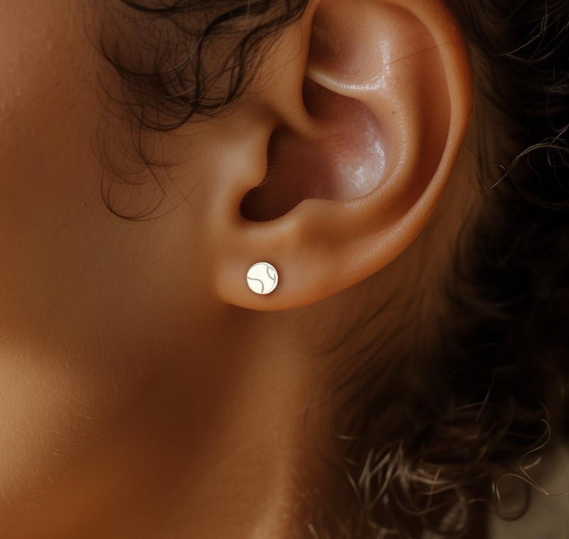 Pair of very small round gold tennis ball stud earrings with seam detail (8 of 10)