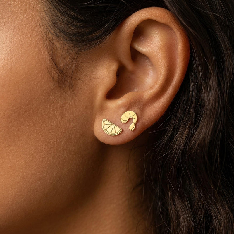 Mismatched gold stud earrings, a curled shrimp and a lemon wedge, on white (2 of 8)
