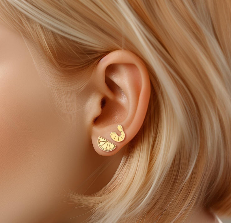 Mismatched gold stud earrings, a curled shrimp and a lemon wedge, on white (5 of 8)