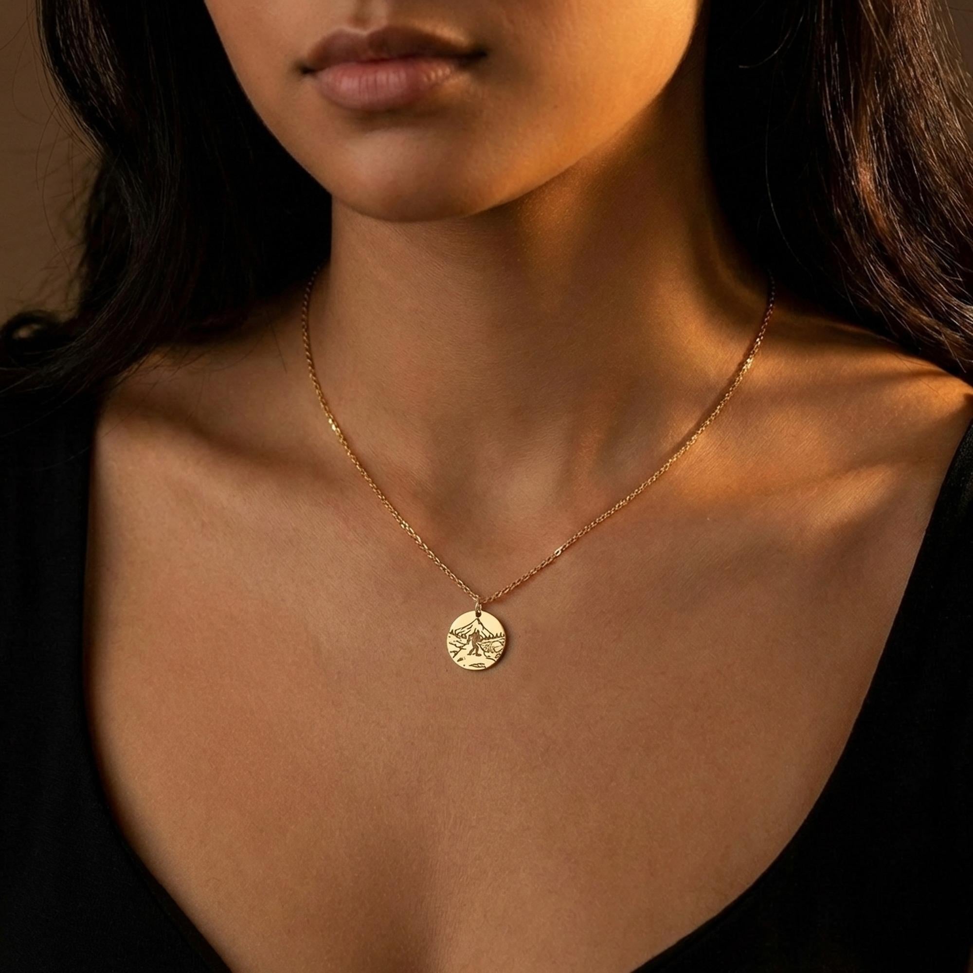 Round gold Bigfoot medallion pendant on a fine chain, shown on a white background. (2 of 9)