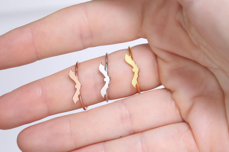 Slim gold ring with a tiny flat bat charm sitting on the band (10 of 15)