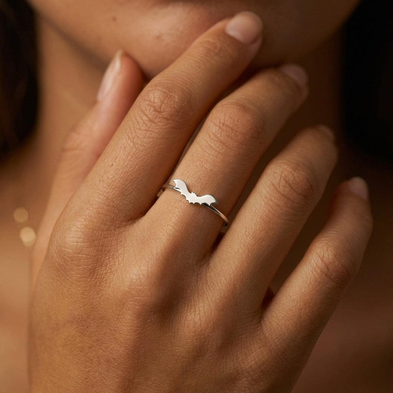 Slim gold ring with a tiny flat bat charm sitting on the band (4 of 15)