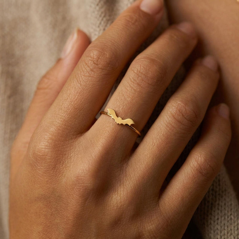 Slim gold ring with a tiny flat bat charm sitting on the band (6 of 15)