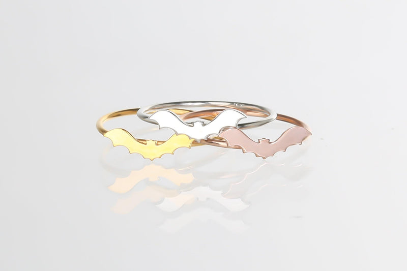 Slim gold ring with a tiny flat bat charm sitting on the band (8 of 15)