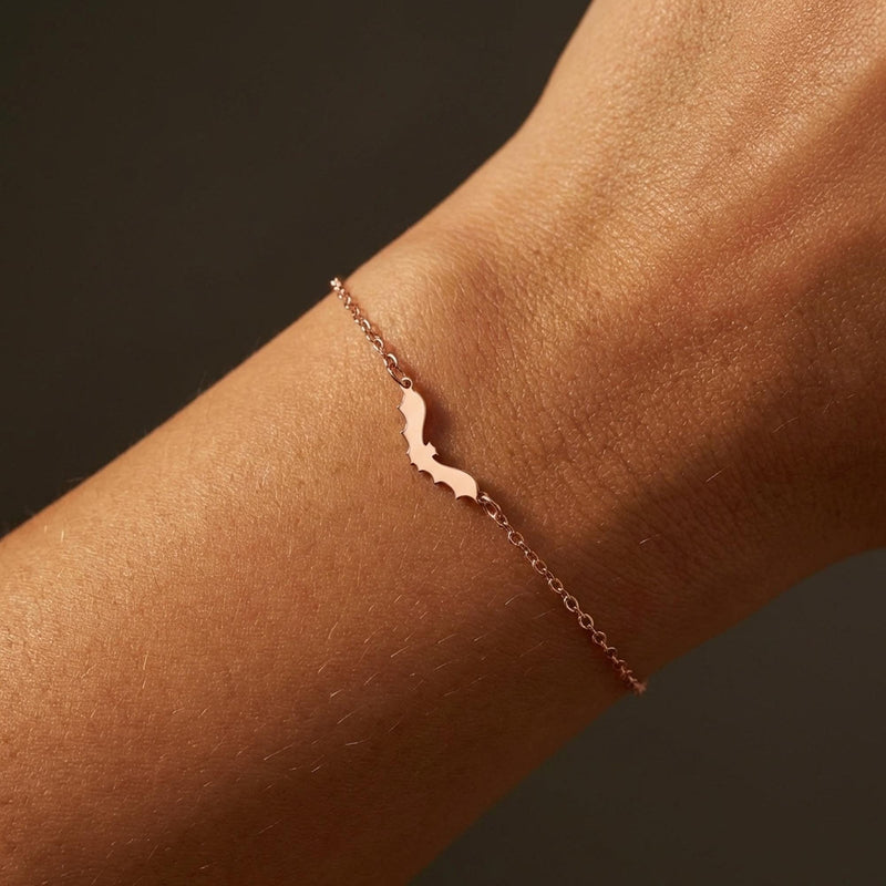Thin gold chain bracelet with a small bat charm with spread wings (5 of 10)