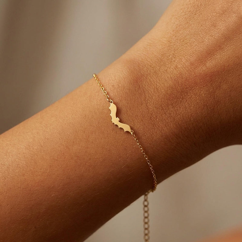 Thin gold chain bracelet with a small bat charm with spread wings (6 of 10)