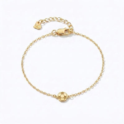 Fine gold chain bracelet with a small soccer ball charm and extender on a wrist