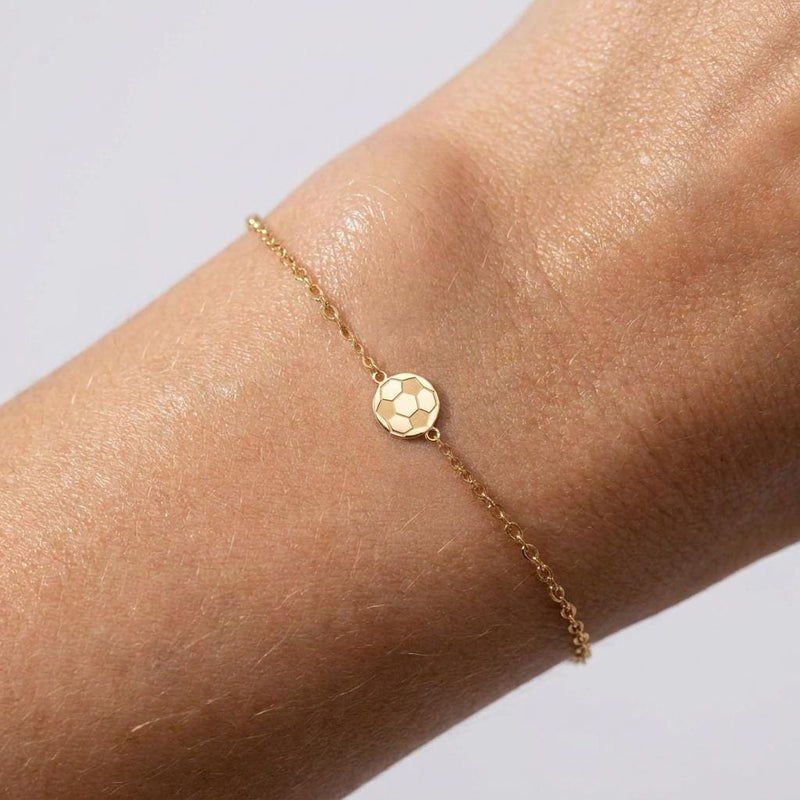 Fine gold chain bracelet with a small soccer ball charm and extender on a wrist (2 of 7)