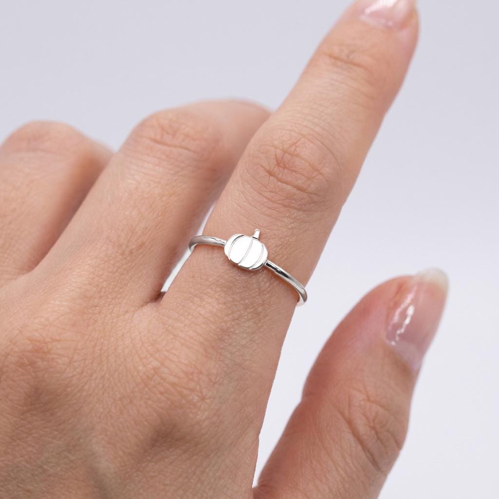 Slim gold ring with a small ribbed pumpkin charm resting on the band (2 of 10)