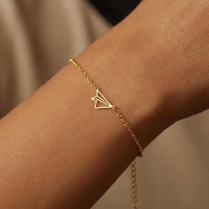 Fine gold chain bracelet with a small folded paper airplane charm (2 of 14)