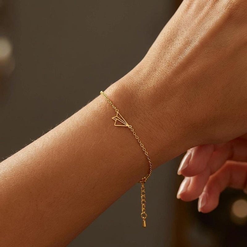 Fine gold chain bracelet with a small folded paper airplane charm (3 of 14)