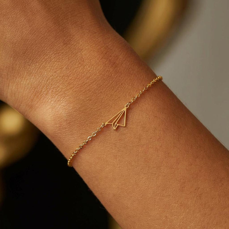 Fine gold chain bracelet with a small folded paper airplane charm (4 of 14)