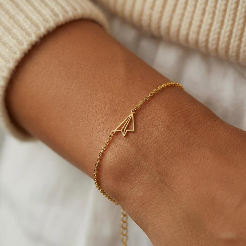 Fine gold chain bracelet with a small folded paper airplane charm (5 of 14)