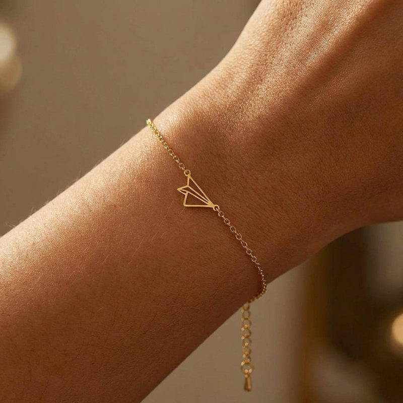 Fine gold chain bracelet with a small folded paper airplane charm (6 of 14)