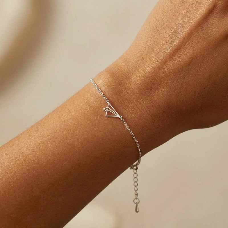 Fine gold chain bracelet with a small folded paper airplane charm (7 of 14)