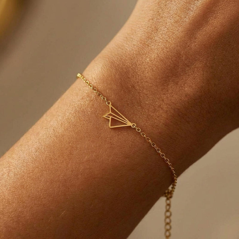 Fine gold chain bracelet with a small folded paper airplane charm (8 of 14)