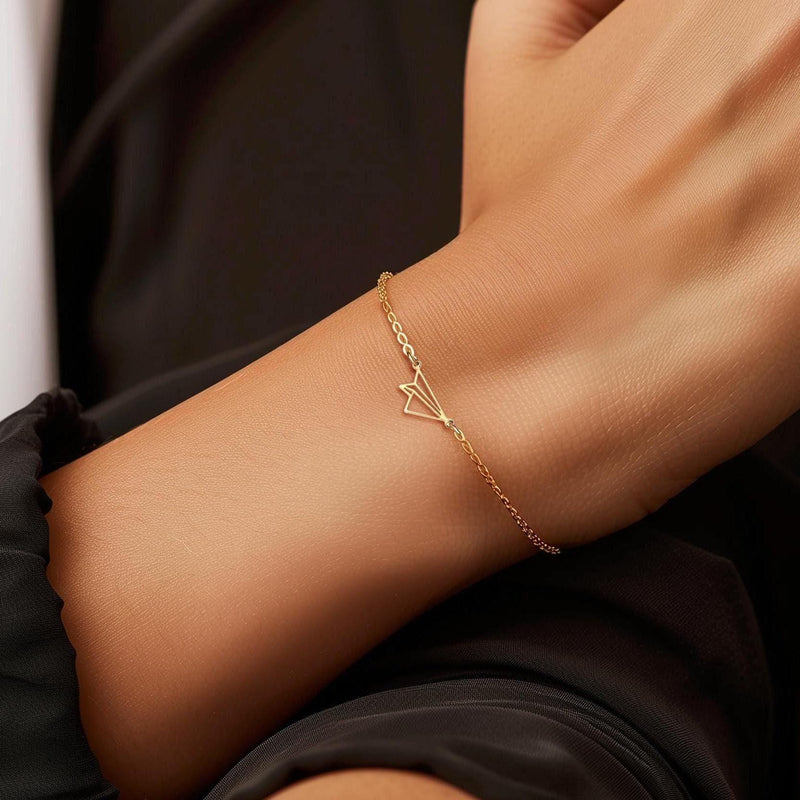 Fine gold chain bracelet with a small folded paper airplane charm (9 of 14)