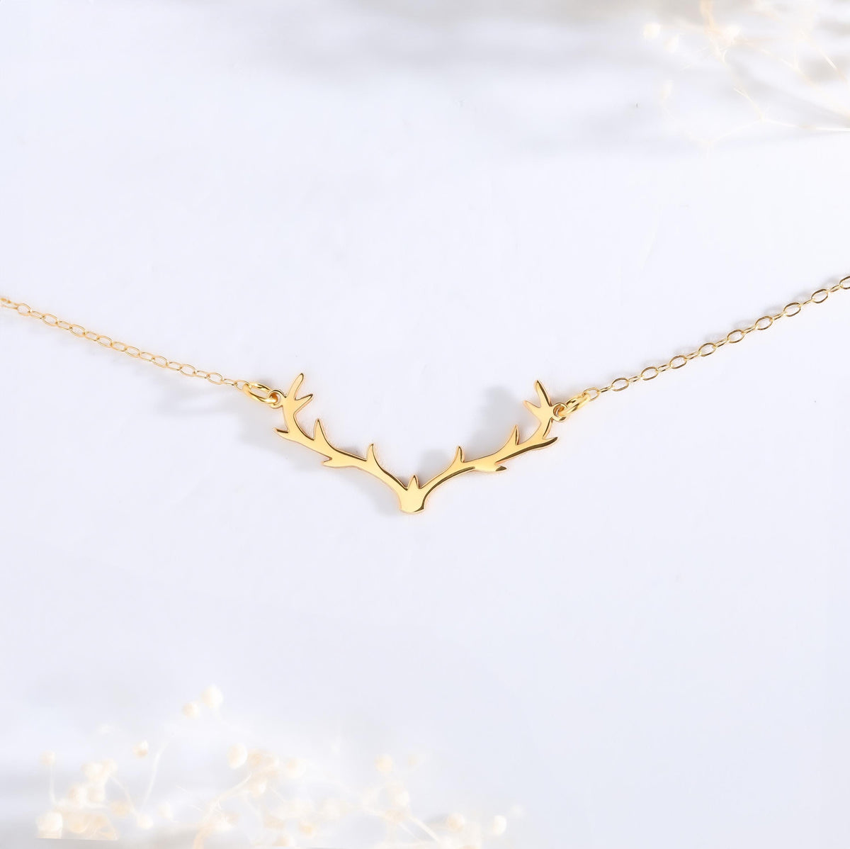 Gold branched reindeer antler pendant hanging from a thin cable chain