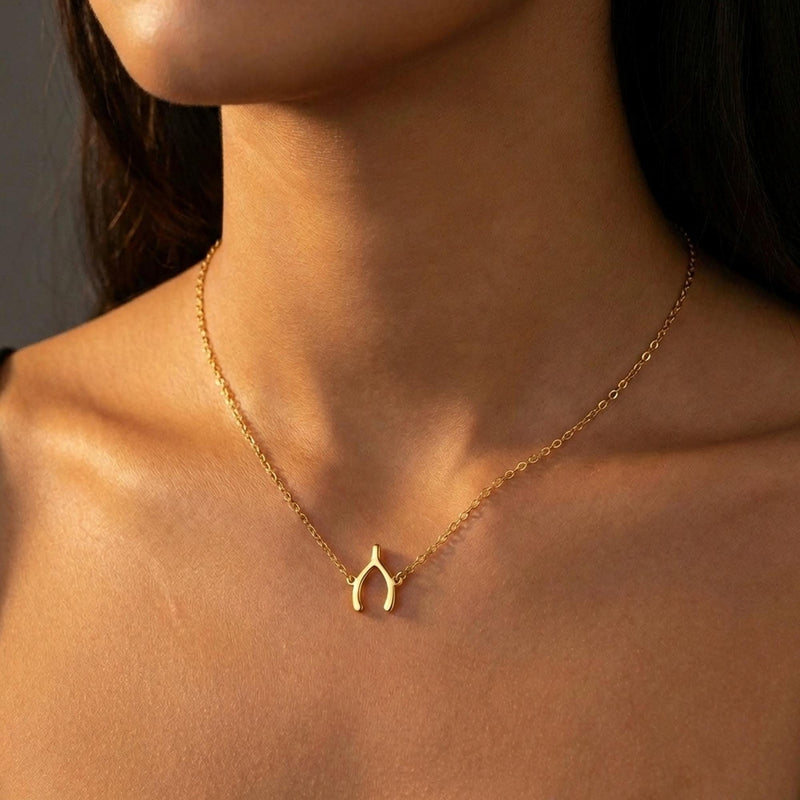 Small gold wishbone pendant hanging from a fine cable chain (10 of 12)