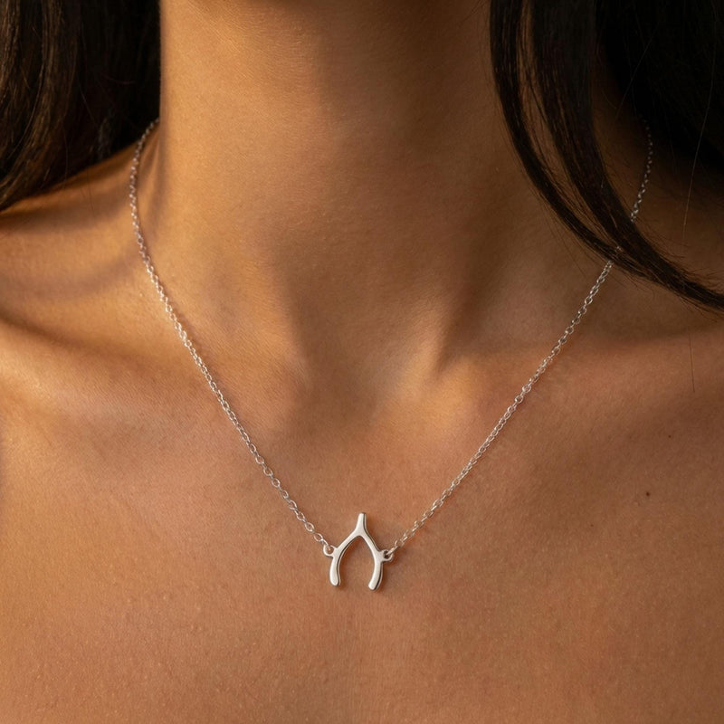 Small gold wishbone pendant hanging from a fine cable chain (12 of 12)