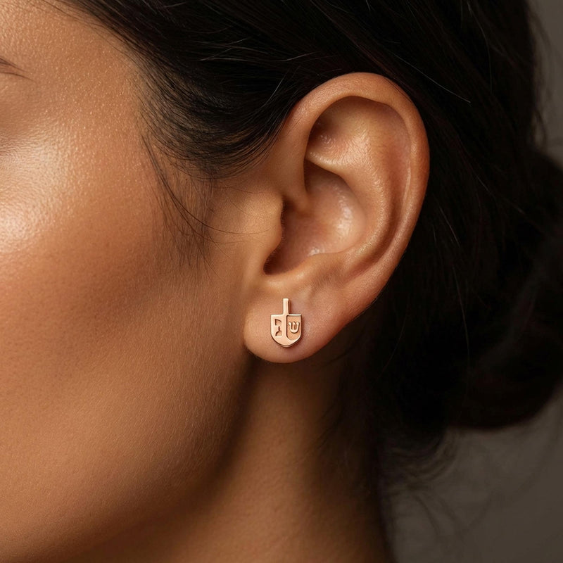 Pair of small gold dreidel stud earrings with a short handle and flat faces. (5 of 8)