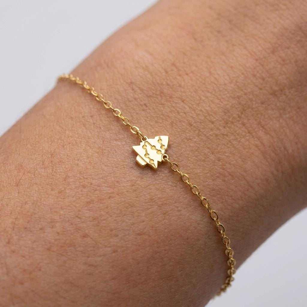 Fine gold chain bracelet with a small tiered Christmas tree charm
