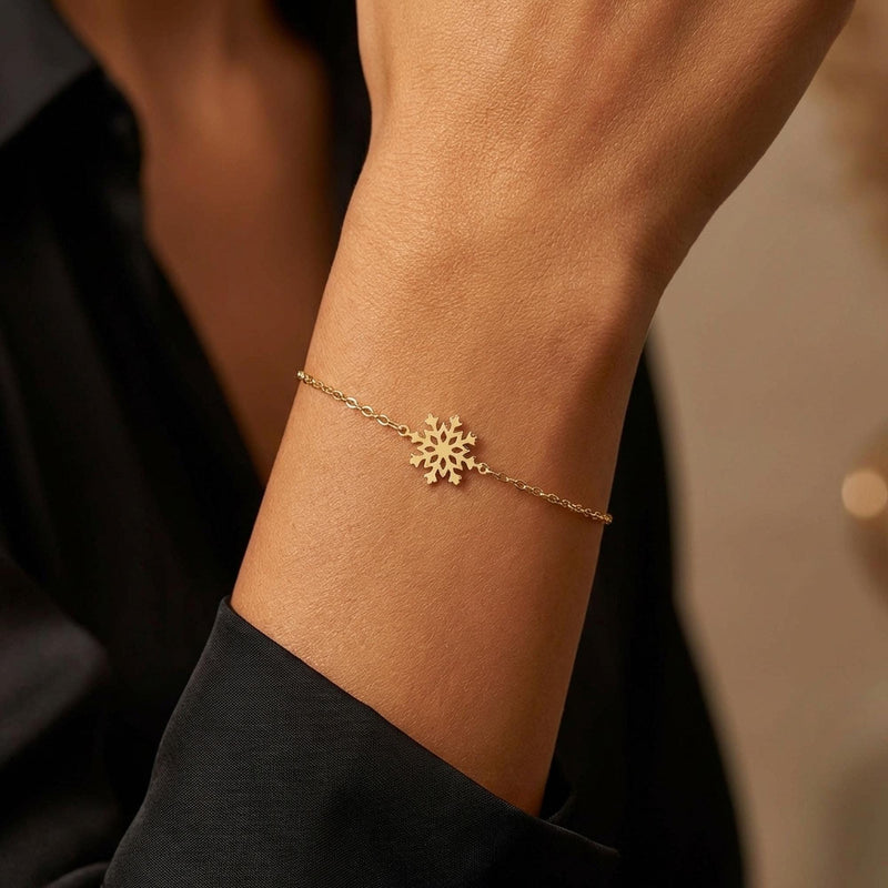 Fine gold bracelet with a small six armed snowflake charm (2 of 9)