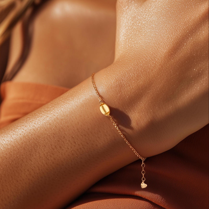 Thin gold chain bracelet with a small football charm showing laces (2 of 8)
