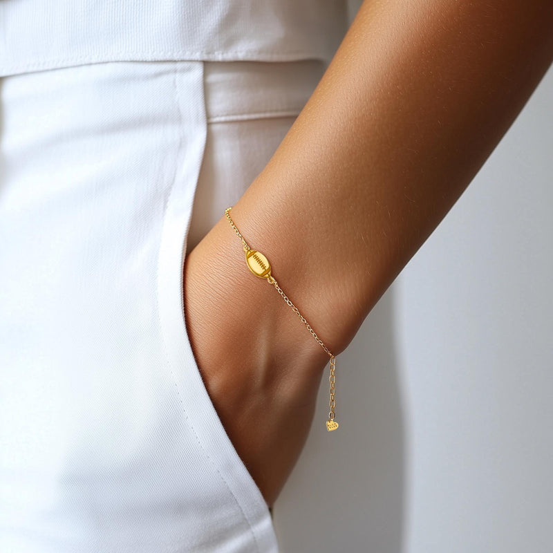 Thin gold chain bracelet with a small football charm showing laces (3 of 8)