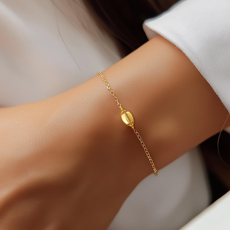 Thin gold chain bracelet with a small football charm showing laces (6 of 8)