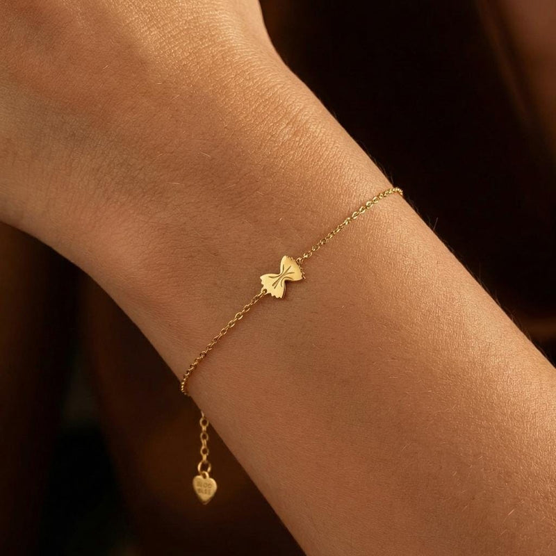 Tiny gold bowtie pasta charm on a fine cable chain bracelet (3 of 7)