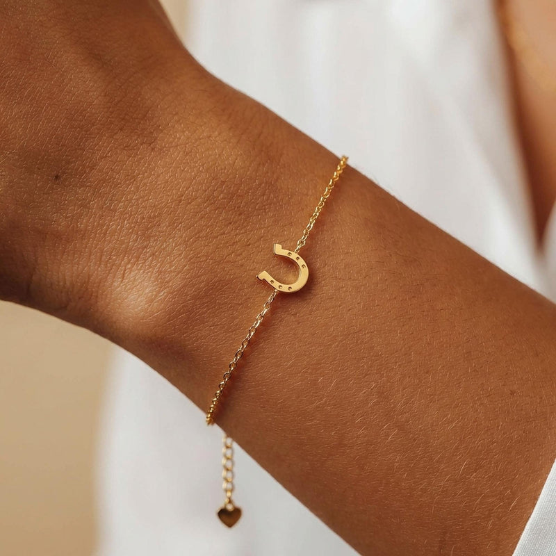Fine chain bracelet with a small flat gold horseshoe charm. (2 of 12)