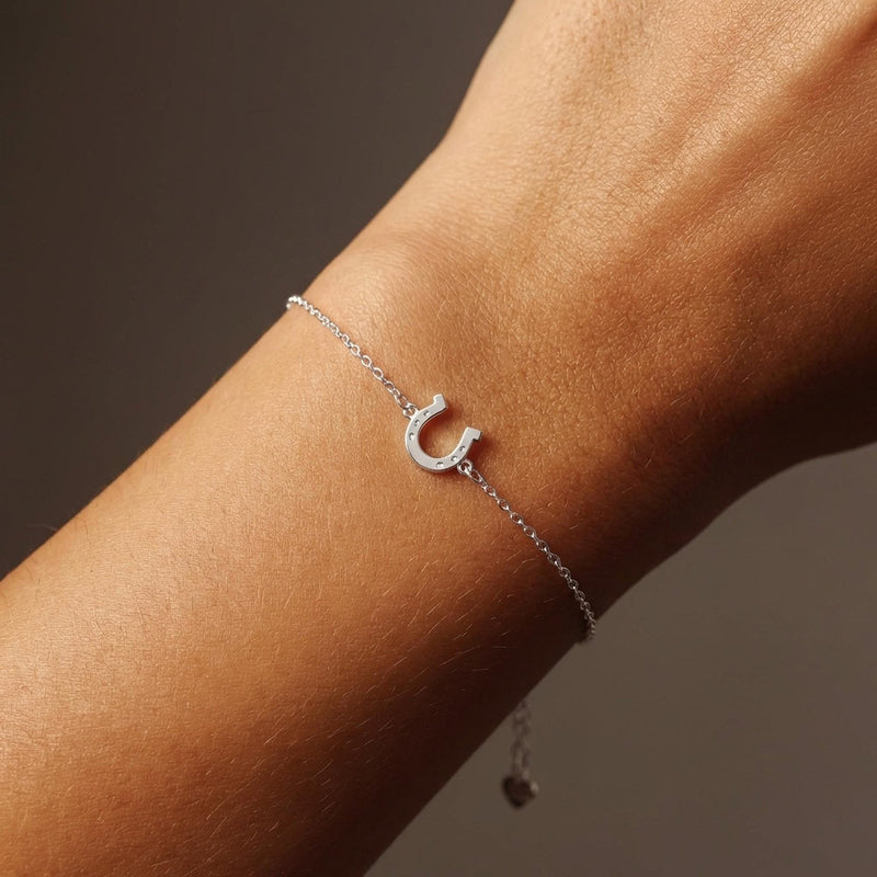 Fine chain bracelet with a small flat gold horseshoe charm. (3 of 12)