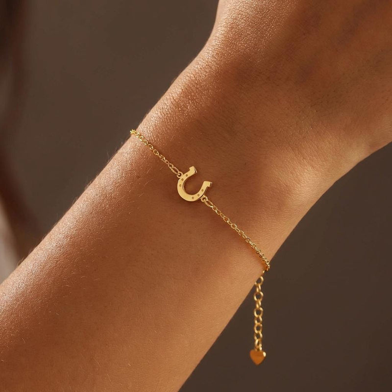 Fine chain bracelet with a small flat gold horseshoe charm. (4 of 12)