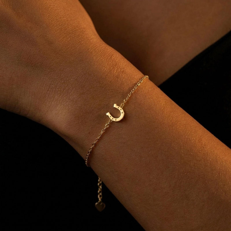 Fine chain bracelet with a small flat gold horseshoe charm. (6 of 12)