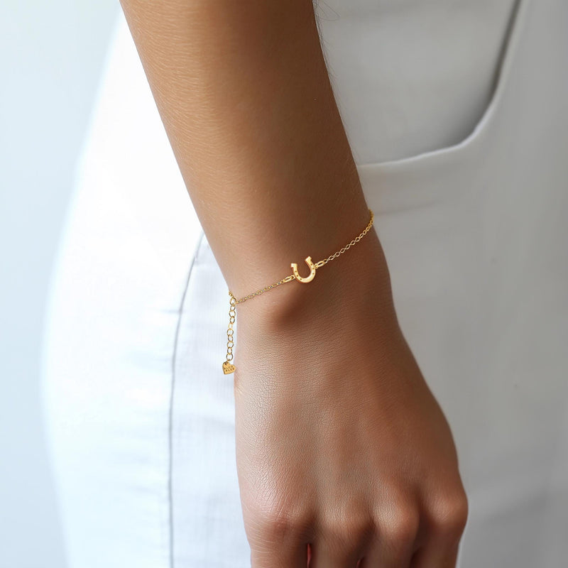 Fine chain bracelet with a small flat gold horseshoe charm. (7 of 12)