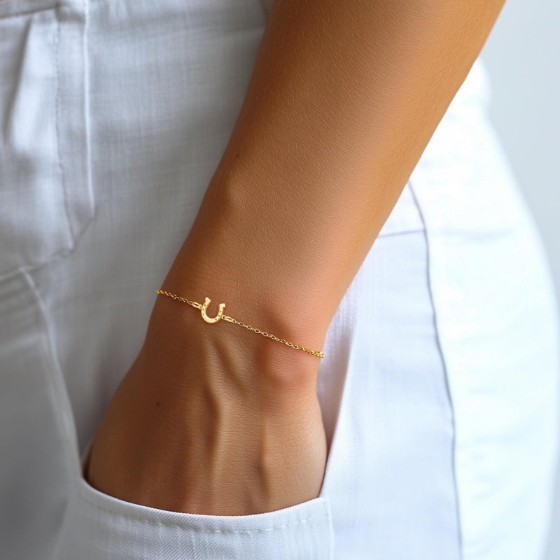 Fine chain bracelet with a small flat gold horseshoe charm. (8 of 12)