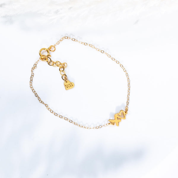 Fine gold chain bracelet with a small XOXO letter charm