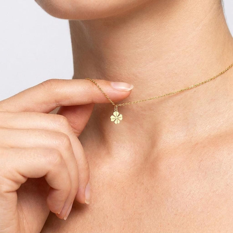 Fine gold chain necklace with a very small four leaf clover pendant
