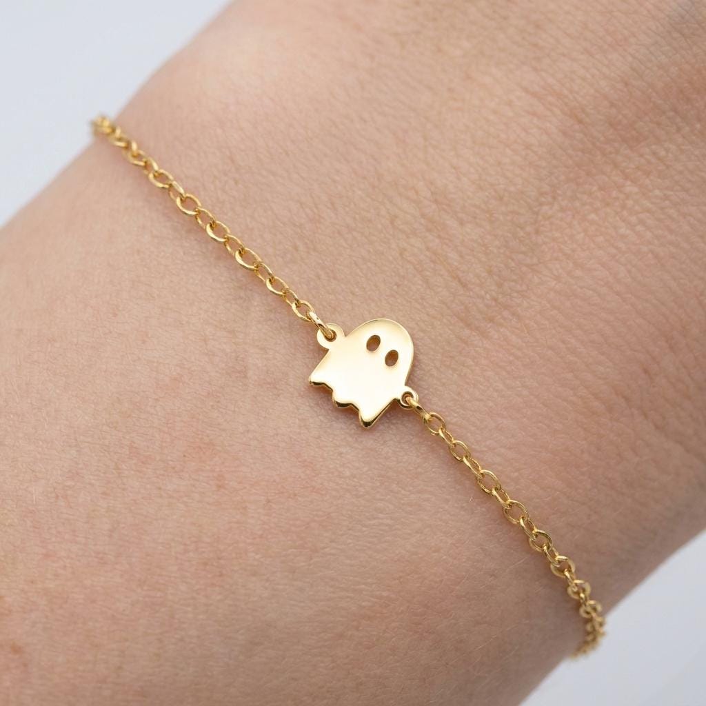 Fine gold chain bracelet with a tiny ghost charm with a wavy hem